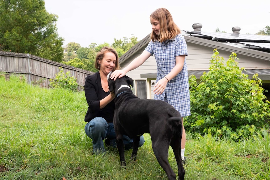 Kate Friend in her garden with her daughter and their dog