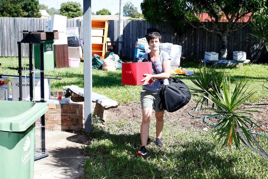 Ashleigh McGrogan returns her belongings after floodwaters recede near Logan.