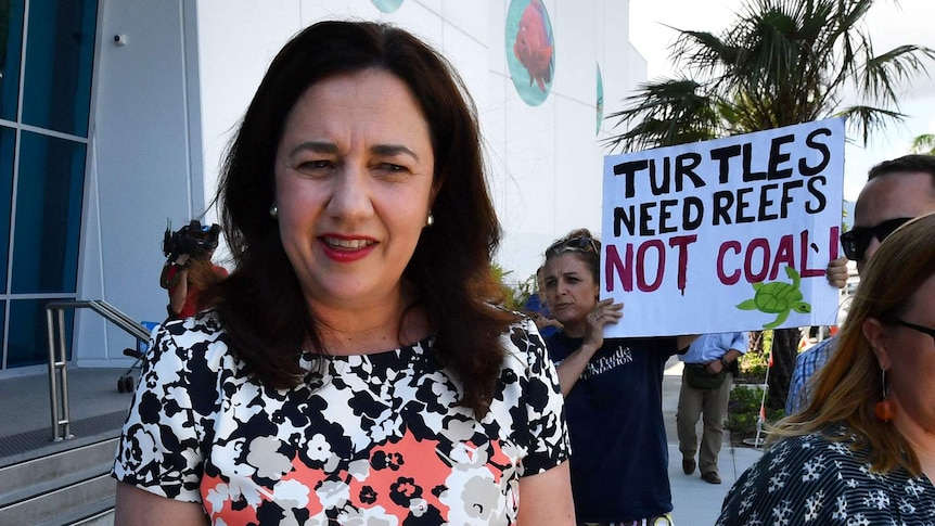 Premier Annastacia Palaszczuk outside Cairns Aquarium, flanked by an anti-Adani protester