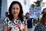 Premier Annastacia Palaszczuk outside Cairns Aquarium, flanked by an anti-Adani protester
