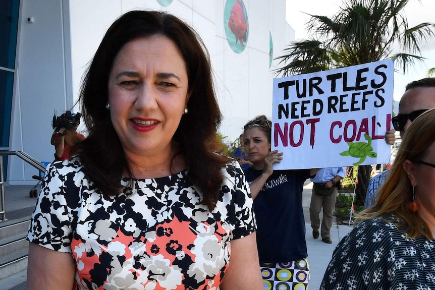 Premier Annastacia Palaszczuk outside Cairns Aquarium, flanked by an anti-Adani protester