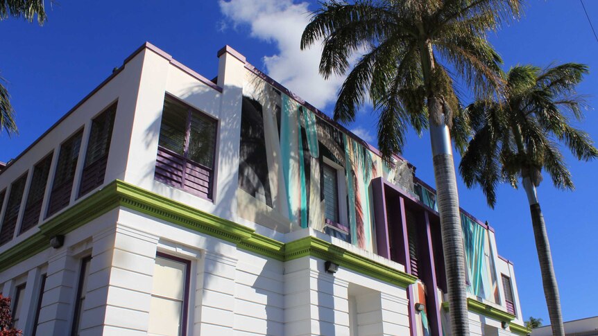 Colourful purple and green building with palm trees
