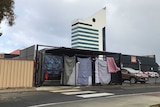 A shelter for Bunbury's homeless community set up in a car park, enclosed with sheets. The Bunbury tower is in the background.