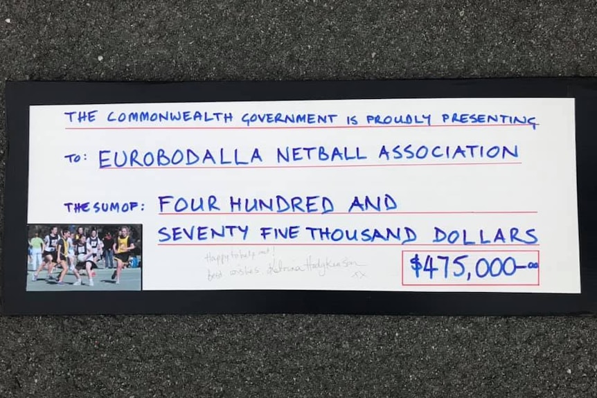 Details of the novelty cheque Katrina Hodgkinson handed to members of the Eurobodalla Netball Association.