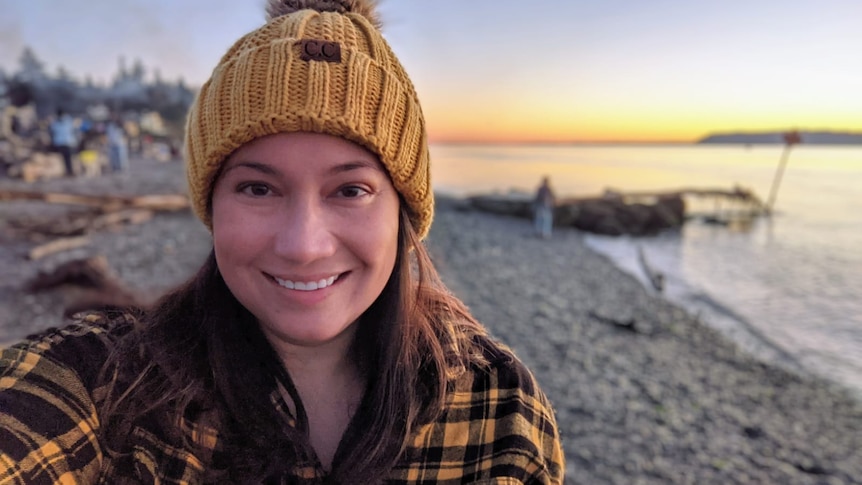 Rose Winter stands on a beach.