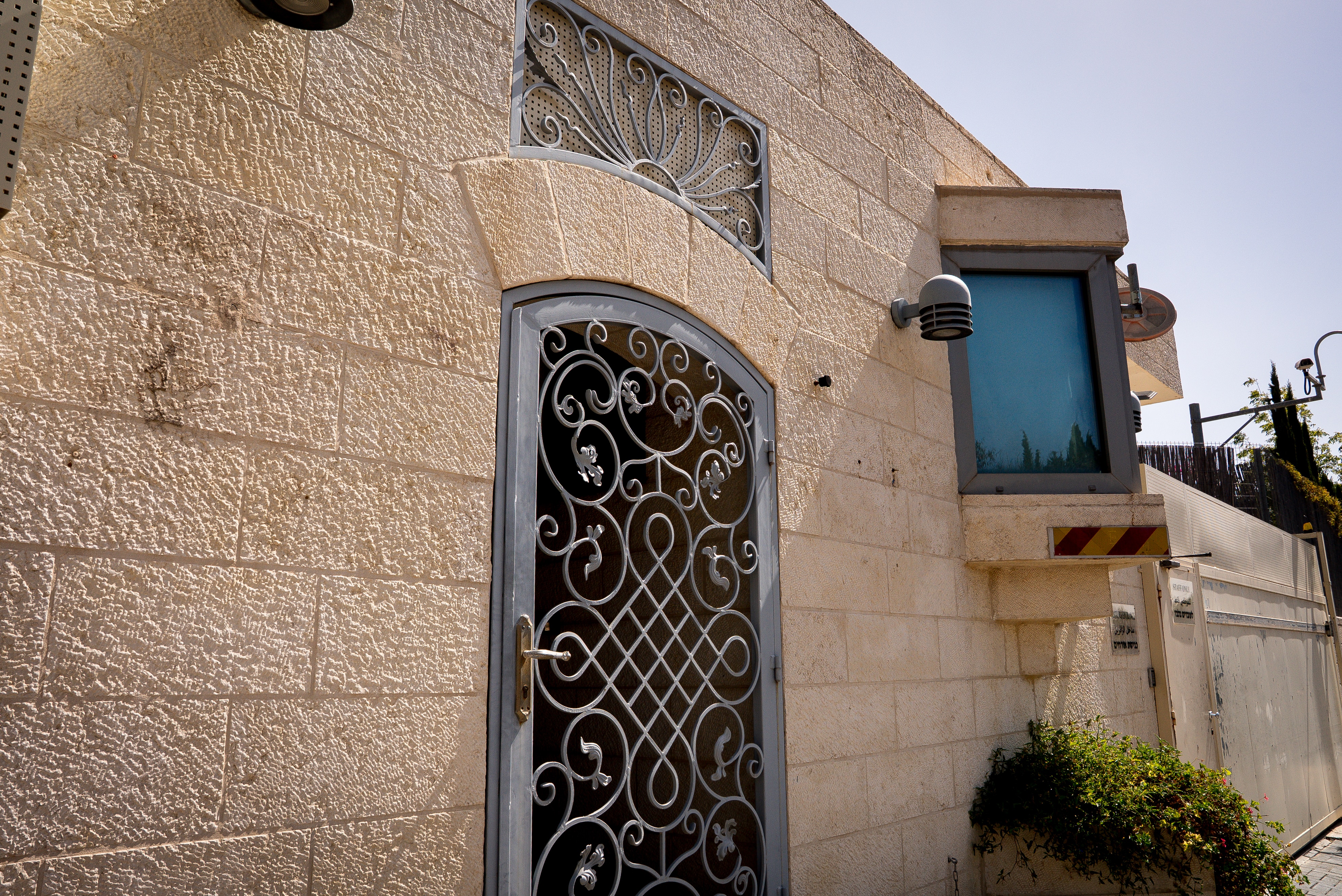 An unmarked stone building showing a front door and security cameras.