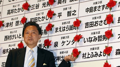 Yukio Hatoyama. leader of Democratic Party of Japan (DPJ), places a flower on the name of a party member during the election,...