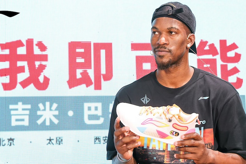 Jimmy Butler holds a Li-Ning sneaker.