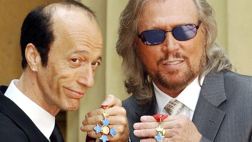 Robin and Barry Gibb hold their CBE's in 2004.