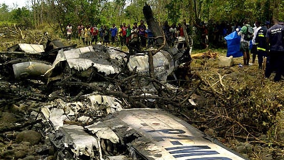 Locals look at the remains of an Airlines PNG Dash 8 plane near Madang in Papua New Guinea on October 14, 2011.