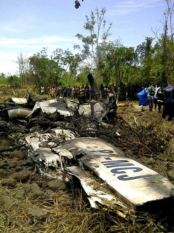 Locals look at the remains of an Airlines PNG Dash 8 plane near Madang in Papua New Guinea on October 14, 2011.