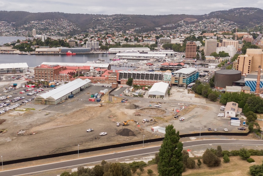 A bare construction site with Hobart's CBD in the distance.