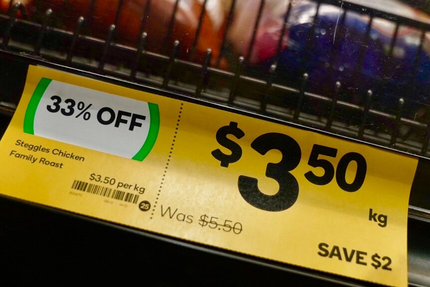 Chicken for sale at the supermarket with a price tag advertising 33 per cent off.