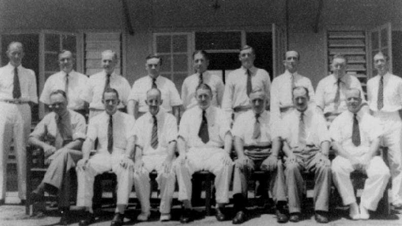 A black and white photo shows the first 14 members of the NT's Legislative Council.