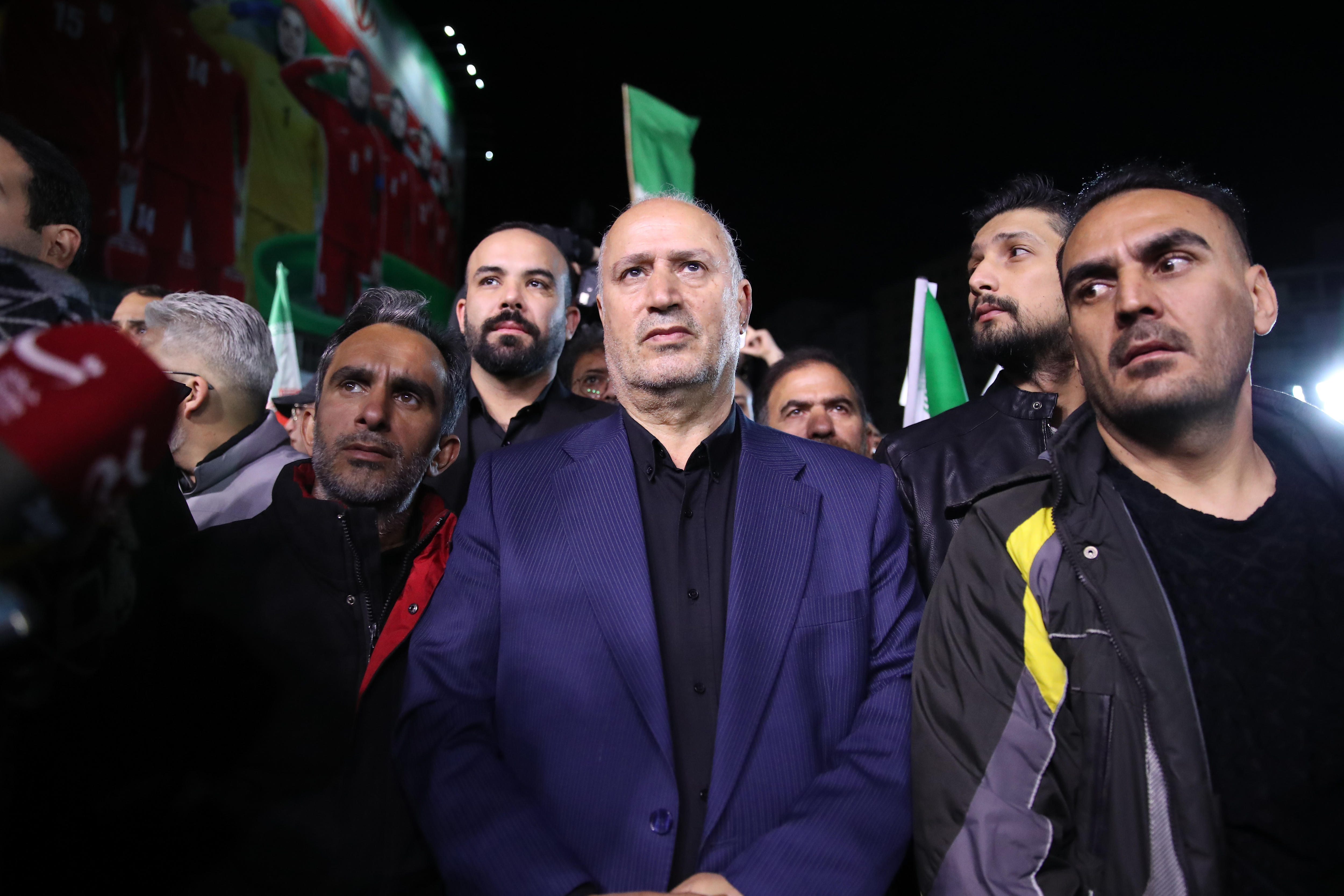 Mehdi Taj walks surrounded by people