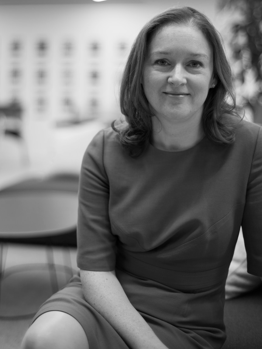 A black and white photograph of a woman in an office.