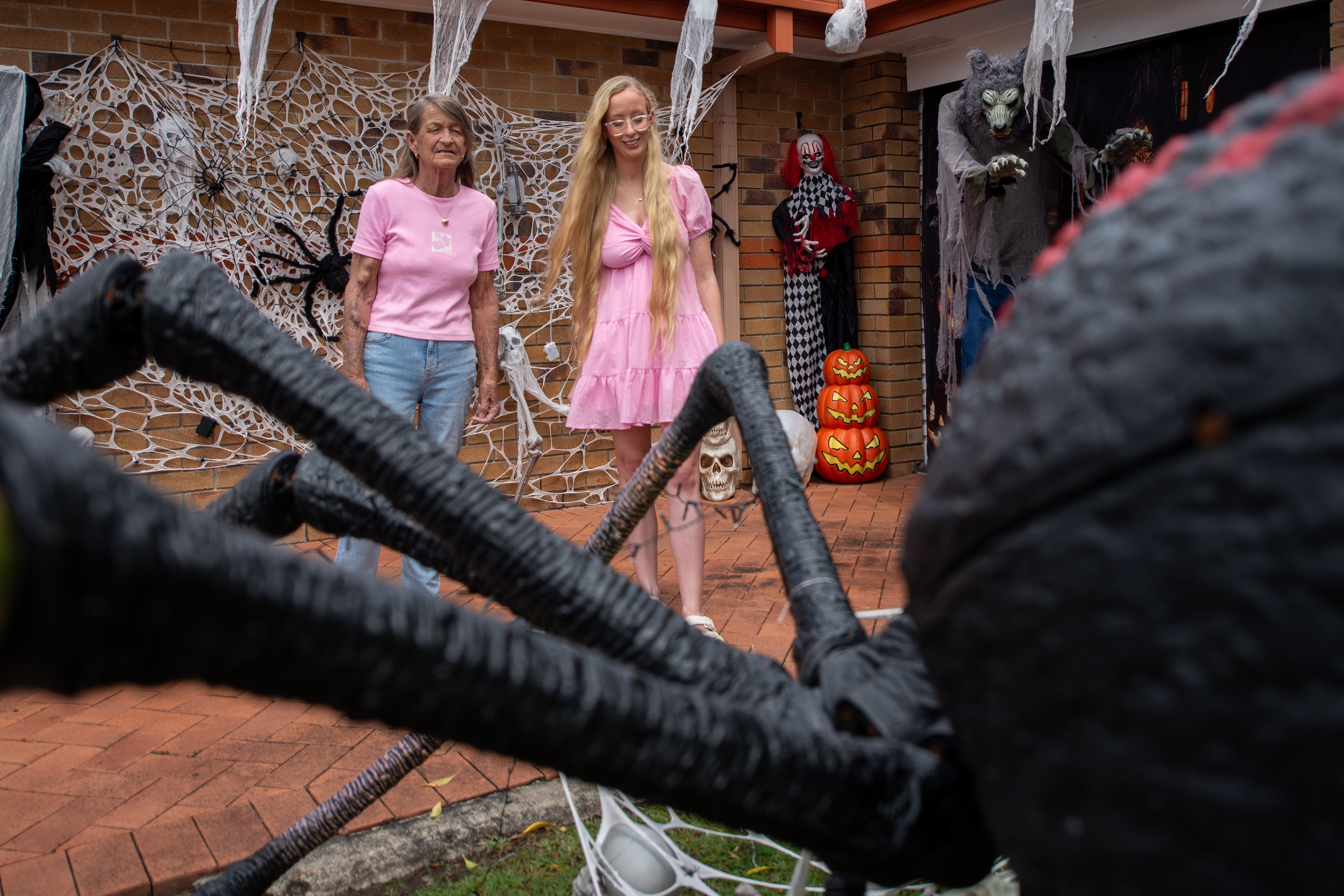 Two women stand behind a massive Halloween display.