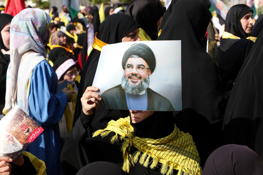 Hezbollah supporter holds up picture of leader Sayyed Hassan 