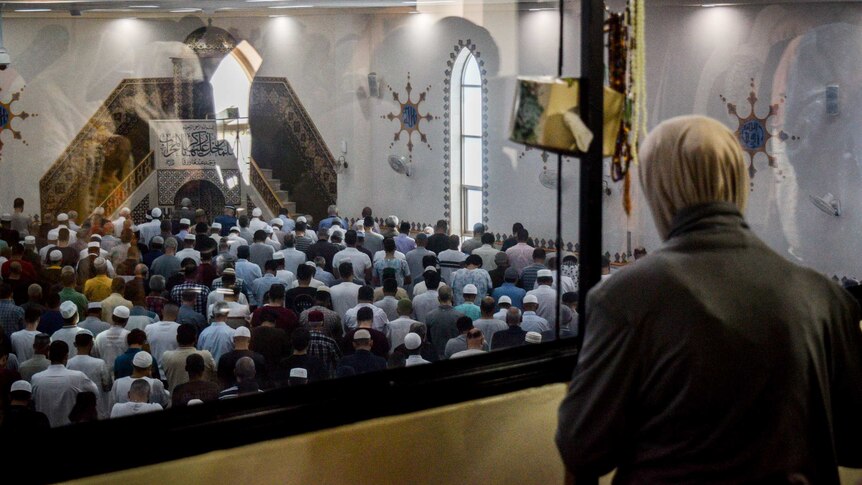 A women looks down over the men's prayer area in Lakemba Moaque.