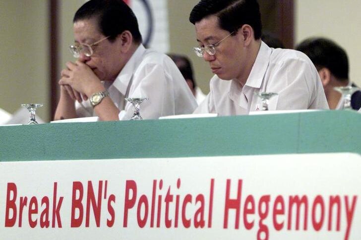 Lim Kit Siang (L) and Lim Guan Eng sitat a table bearing the banner: Break National Front Coalition (BN) Political Hegemony