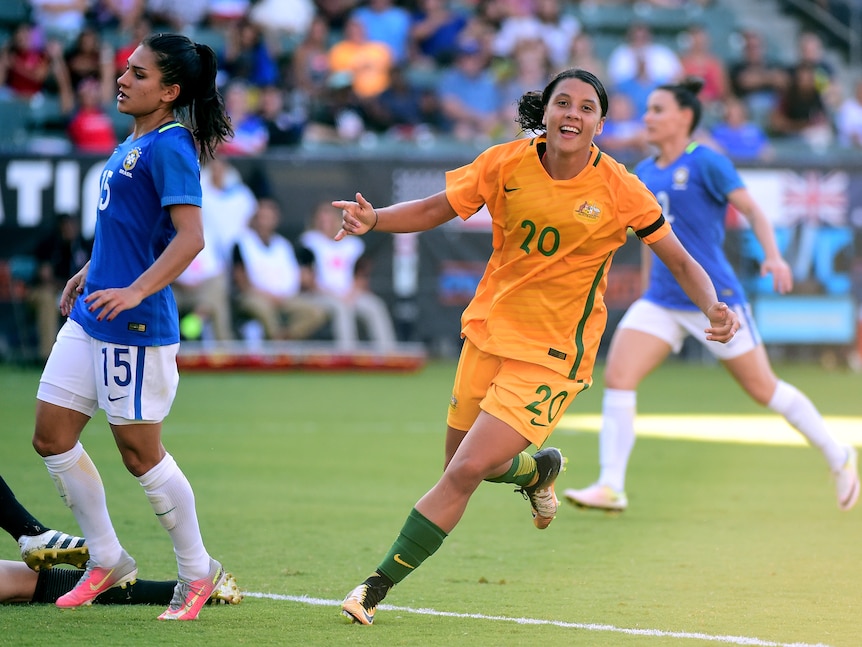 Australia soccer player celebrates scoring a goal against Brazil