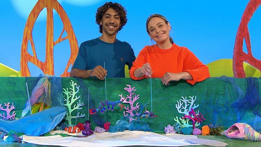 Abi and Hunter holding some hand puppets of sea creatures in an underwater craft scene