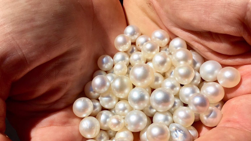 A close up of a handful of pearls