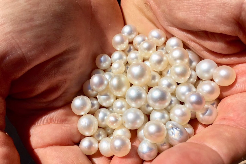 A close up of a handful of pearls