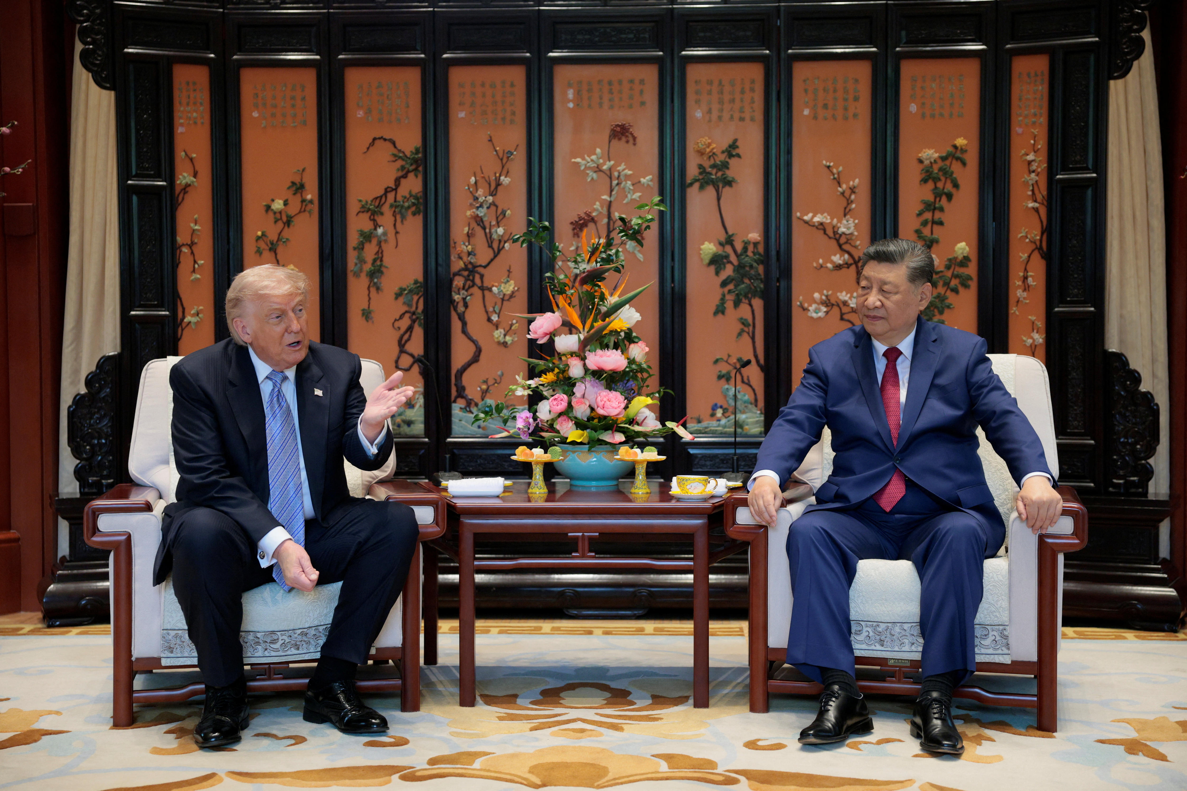 Donald Trump gestures with his hand while he speaks during remarks with Xi Jinping. 