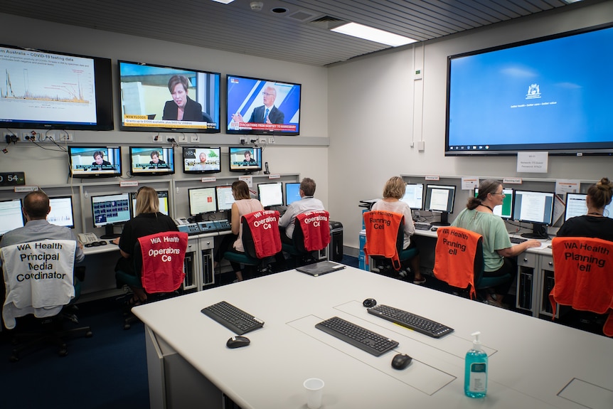 Contact tracers work alongside data analysts who are all working in a control room together.