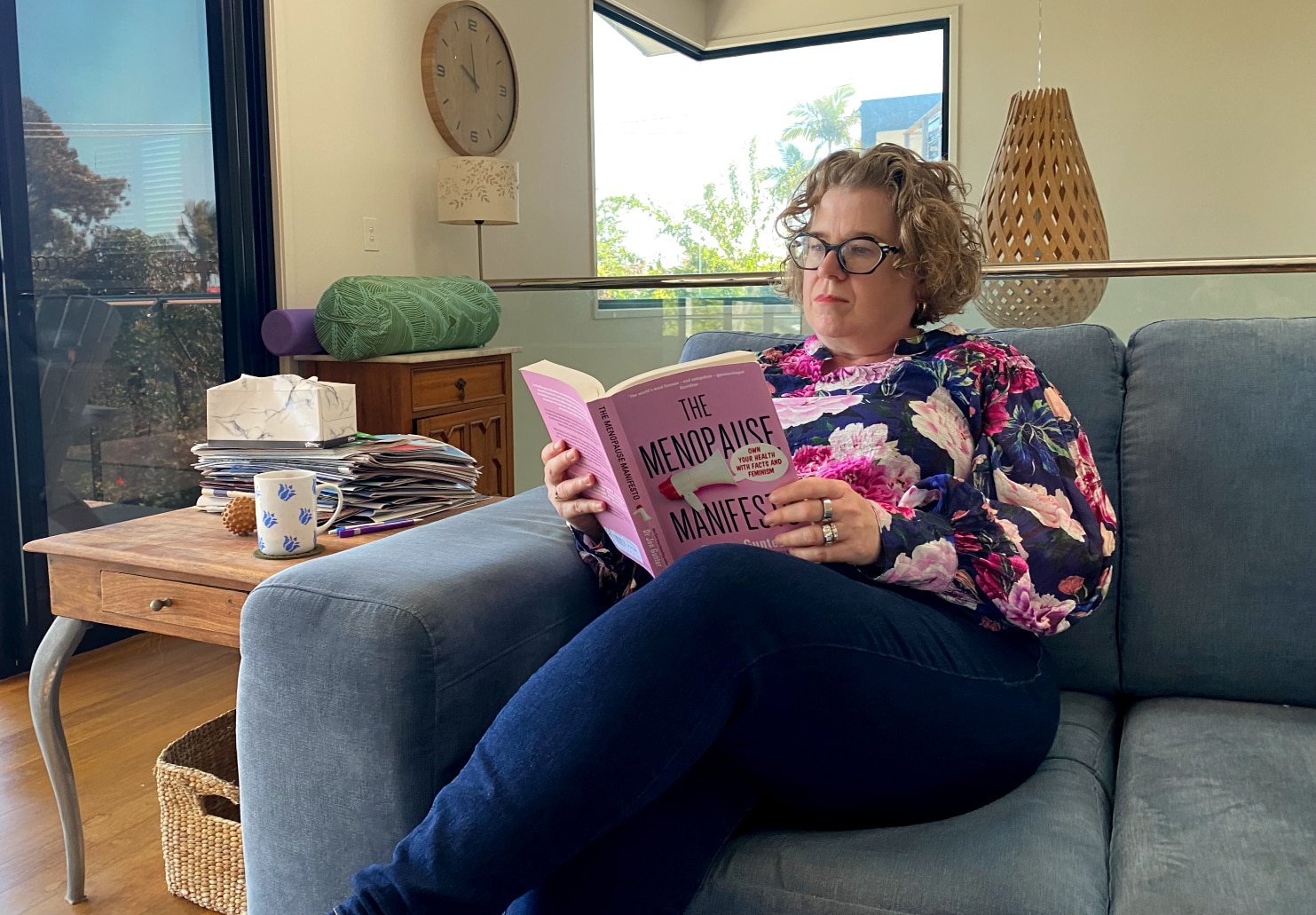 woman reads book on couch 
