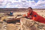 Woman in bright orange spacesuit in the desert in Utah