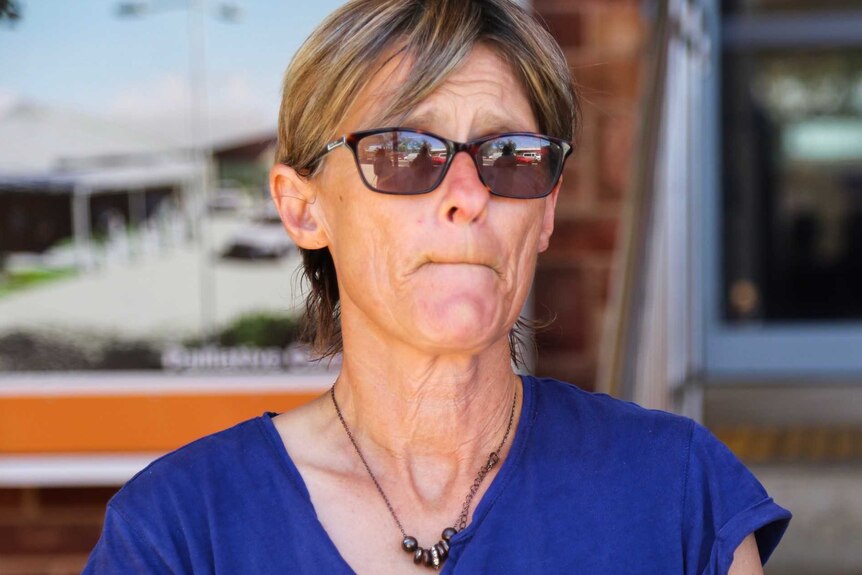 Tamra McBeath-Riley wearing a blur top, glasses and a necklance.