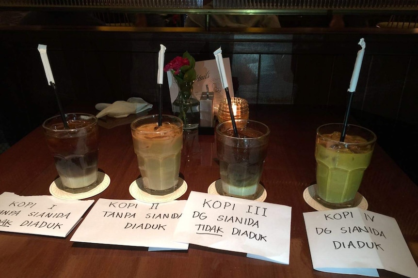 Indonesian police display iced coffee drinks with and without cyanide.