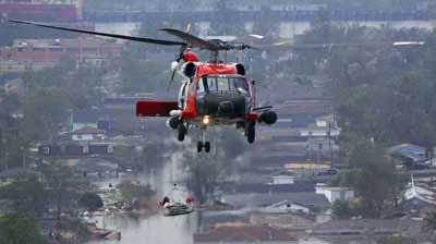 A person is lifted to safety by helicopter in the aftermath of Hurricane Katrina.