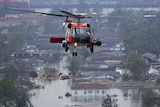 A person is lifted to safety by helicopter in the aftermath of Hurricane Katrina.