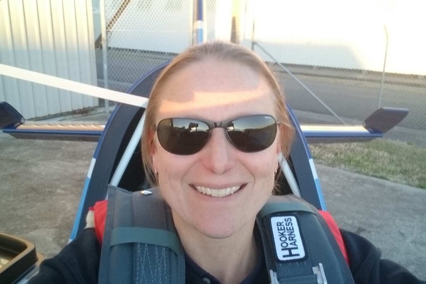 A woman takes a selfie inside the cockpit of a small plane.