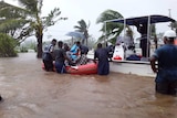 People trying to get in a rescue boat in the middle of flooding in Fiji after cycle Ana hit.
