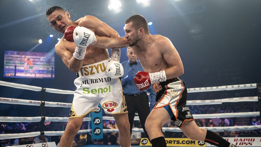 Two men fighting in a boxing ring. 