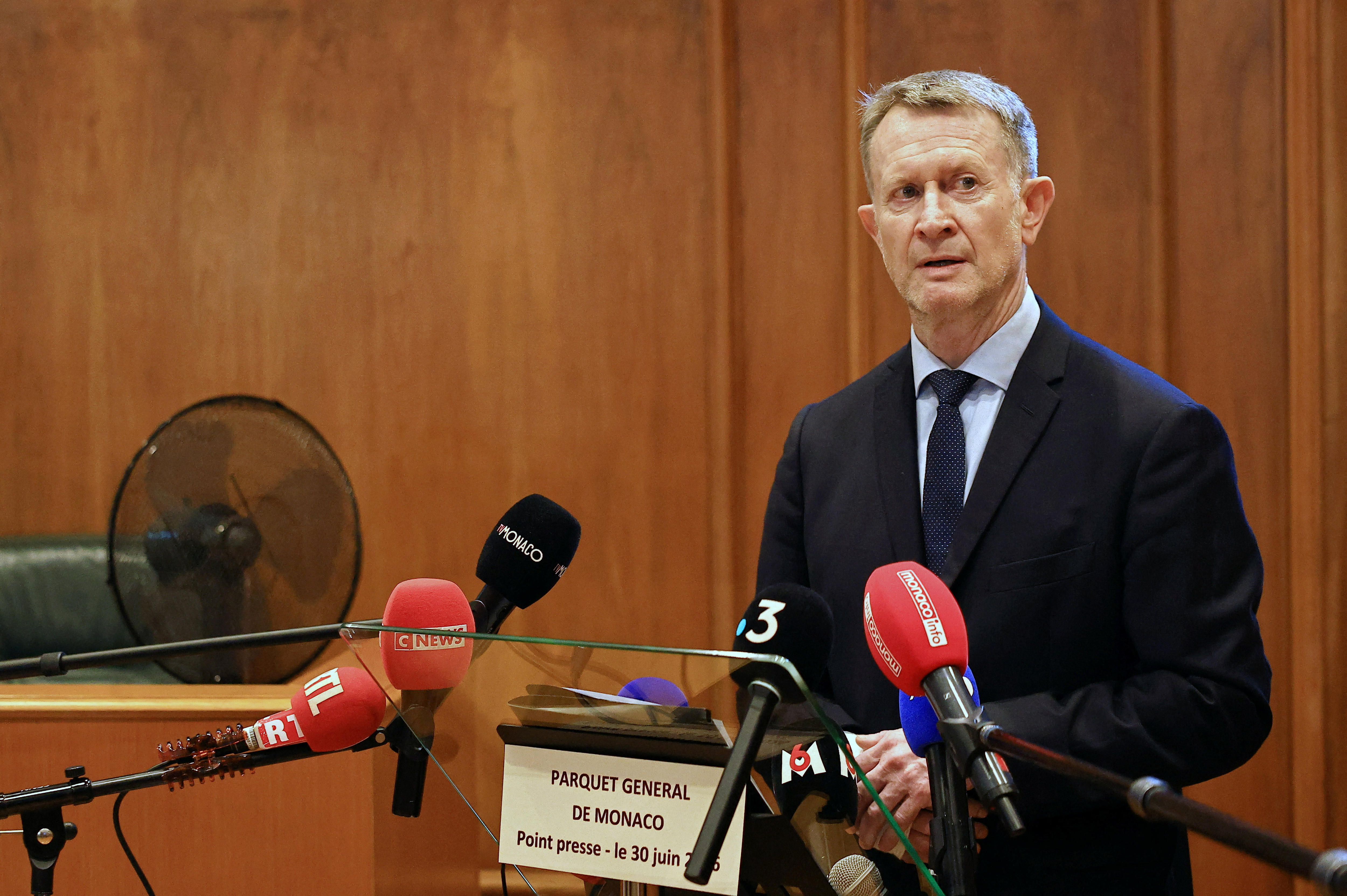 A man speaks at a lectern during a press conference. 