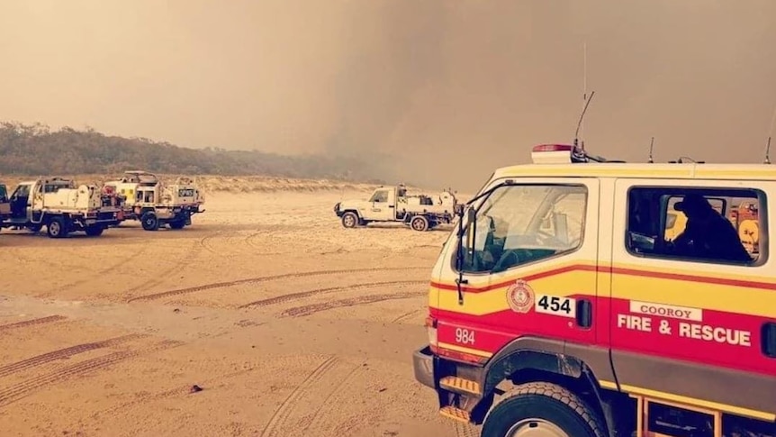 Fire crews park on the beach at Fraser Island while battling a major bushfire, December 7, 2020.