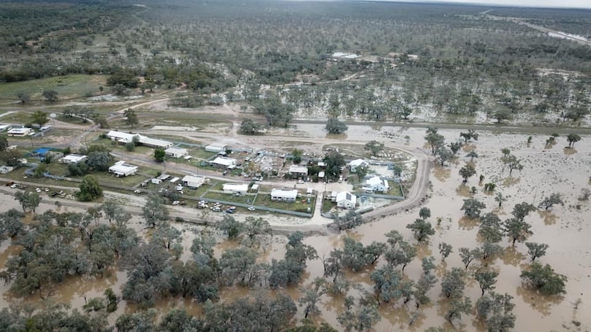 A drone image of buildings in a rural community surrounded by floodwater