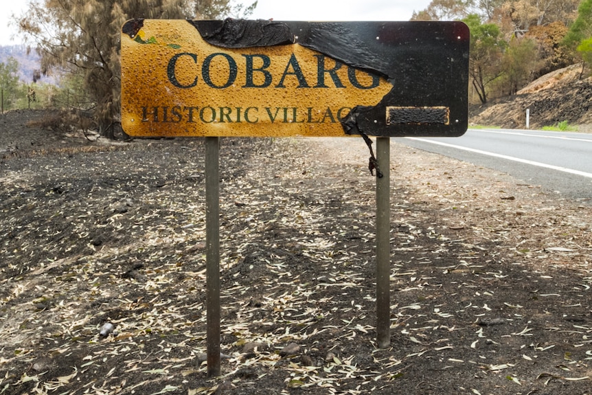 A road sign reading "Cobargo", badly damaged by fire.