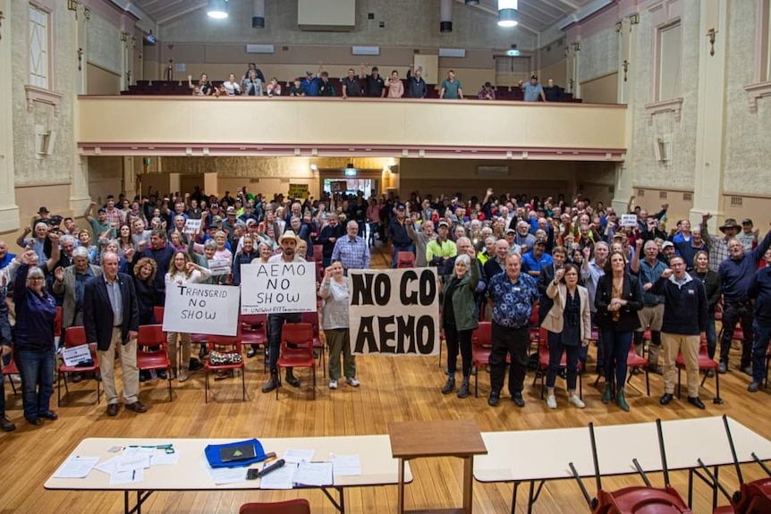 A large group of protesters in a town hall