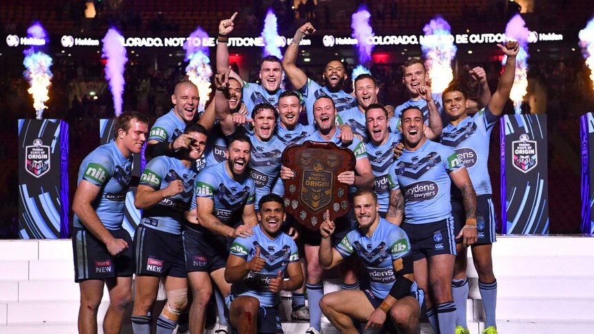 The Blues celebrate with the State of Origin shield.