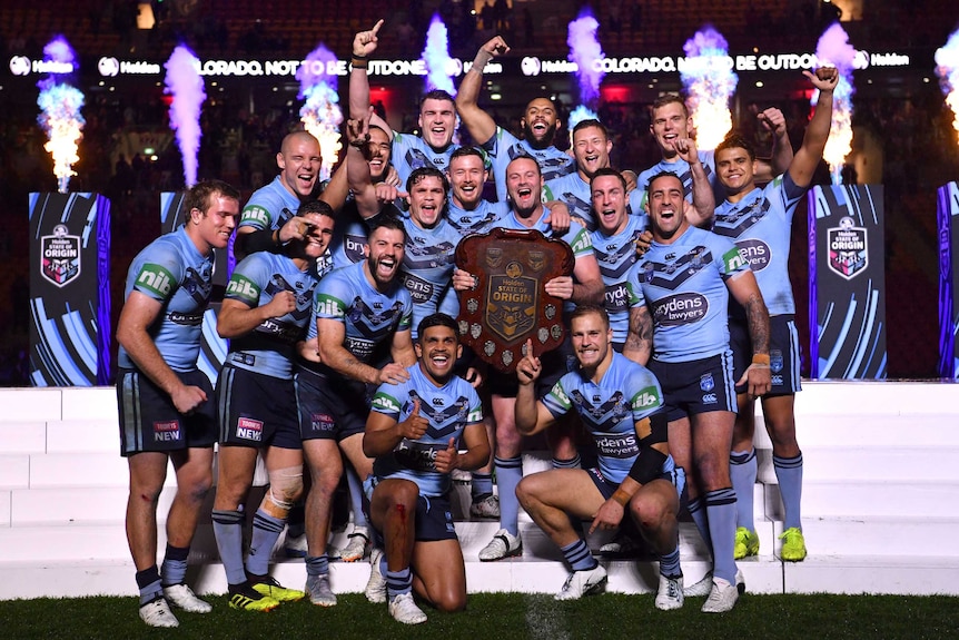 The Blues celebrate with the State of Origin shield.