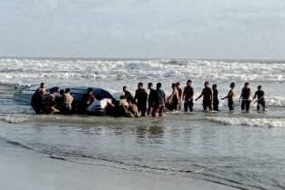 People searching for survivors of a boat capsizing off the coast of Malaysia