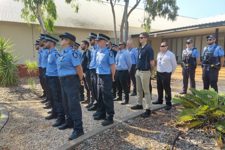 Police officers standing at attention in a courtyard.