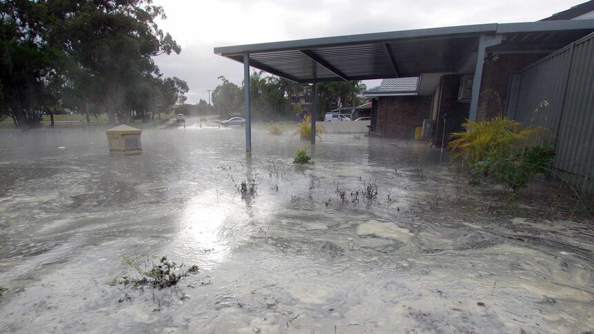 Flooding in a driveway, leaves a letter box partly submerged.