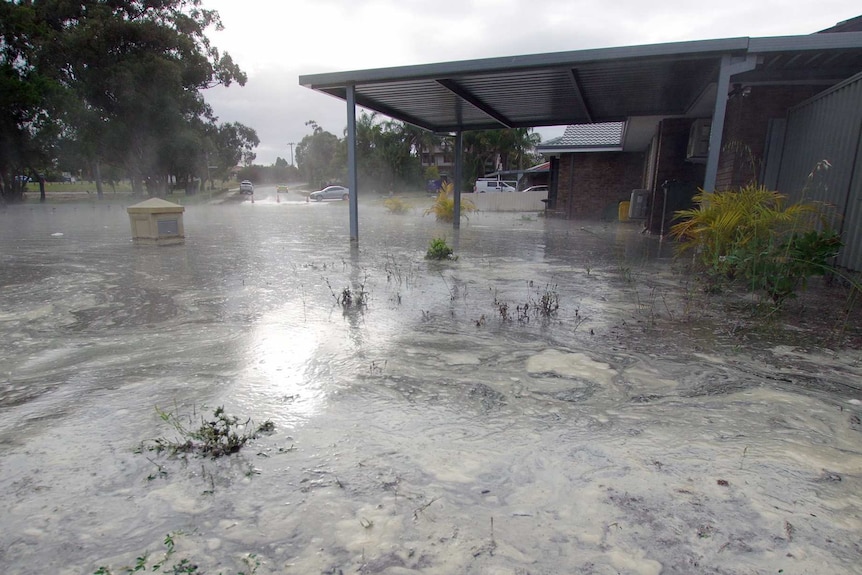 Flooding in a driveway, leaves a letter box partly submerged.